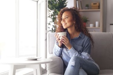 Colț de relaxare cu mobilier minimalist din lemn natural și textile moi – design care inspiră calm și echilibru